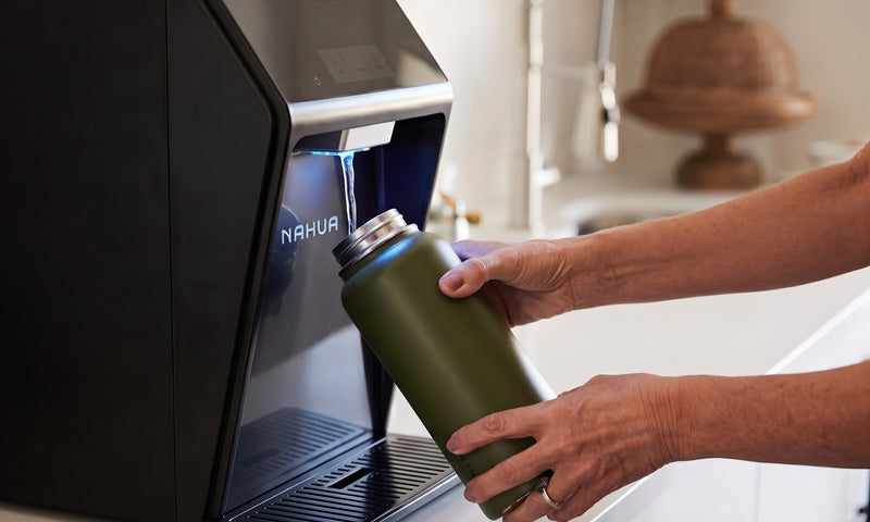 Llenando una botella con agua filtrada en un purificador Nahua